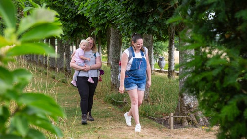 A family walking through the garden at Mottisfont, Hampshire in summer